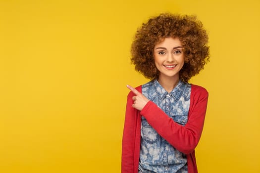 Portrait of emotional curly girl on yellow background.
