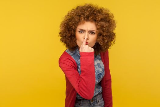 Portrait of emotional curly girl on yellow background.