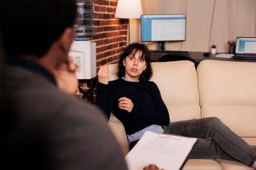 Unhappy woman laying on sofa at psychotherapy session