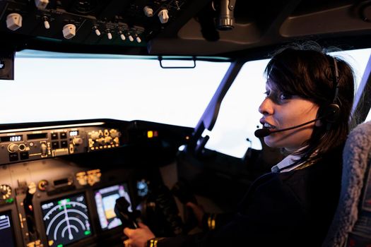 Young copilot using power switch on dashboard to fly aircraft jet