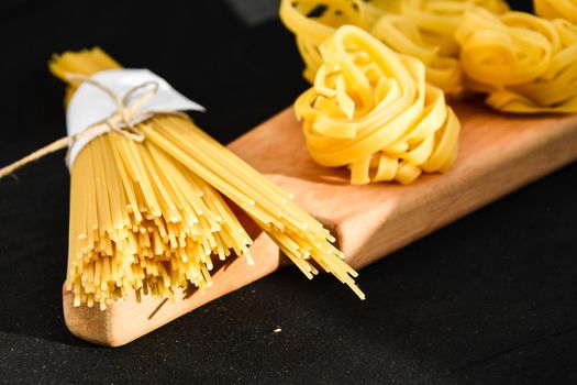 Raw spaghetti and tagliatelle round balls of pasta