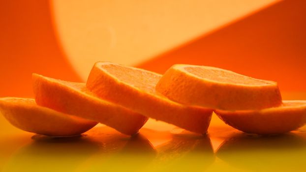 Orange slices on the yellow background - stock photo