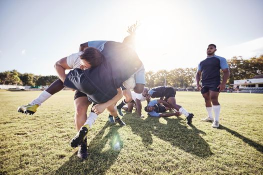 Caucasian rugby player attempting to tackle an opponent during a rugby match outside on the field. Young athletic man tackling an opponent in an attempt to stop him from scoring. Last line of defense