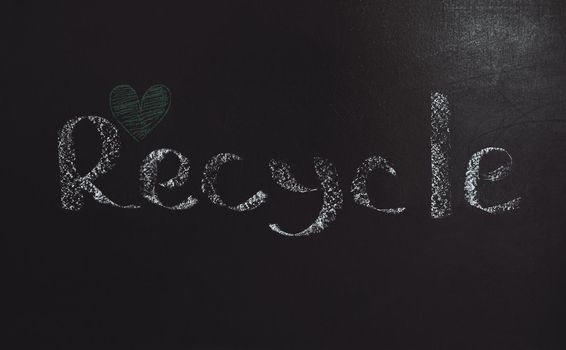 Conceptual Photo of an Environmental Protection. Garbage Recycling. Black Background with Written Word and Little Drawn Green Heart. Save the Planet Earth.