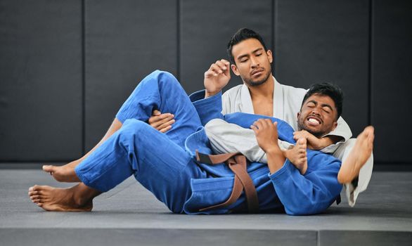 Two judo competitors fighting during practice. Martial arts coach training his student. Two judo competitors fighting during practice. Martial arts coach training his student.