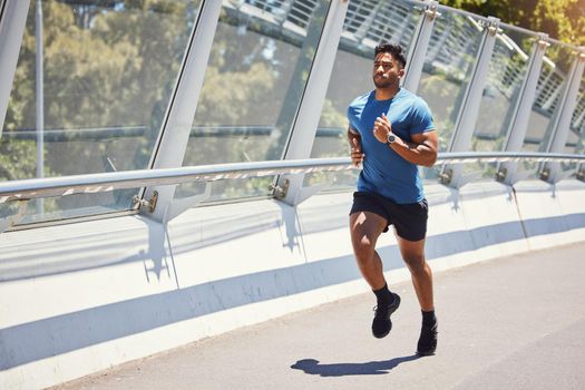 Mixed race man serious about his health. Hispanic male focused on his health while exercising outside. Athletic man doing cardio and training for a marathon outdoors. Jogger determined to keep fit