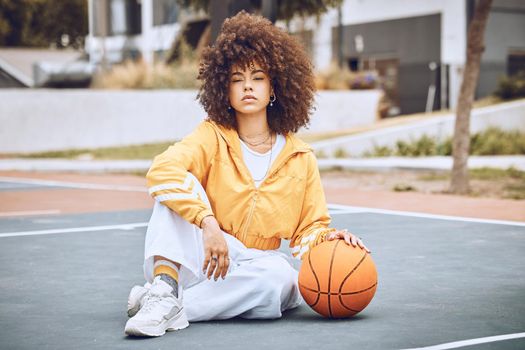 Mixed race woman posing on a basketball court. Beautiful basketball player posing confidently outside