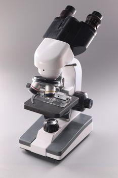 Microscope on gray background Microbiology and healthcare. Scientific equipment for analysis and research.