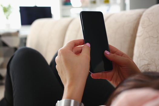 Female laying on couch with smartphone turned off black screen