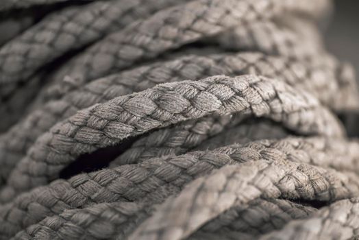 Thick tangled rope close up. Close-up of an old worn out boat rope as a nautical background.