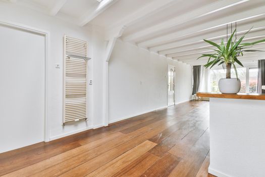 Empty room with white ceiling and beams