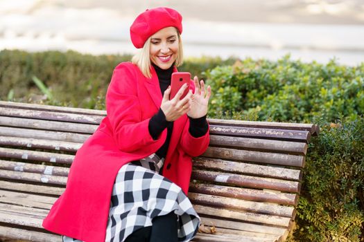 Smiling woman browsing smartphone in park