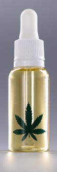 Closeup of bottle of marijuana oil on gray background