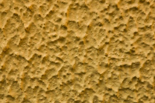 Abstract background of rough yellow plaster.