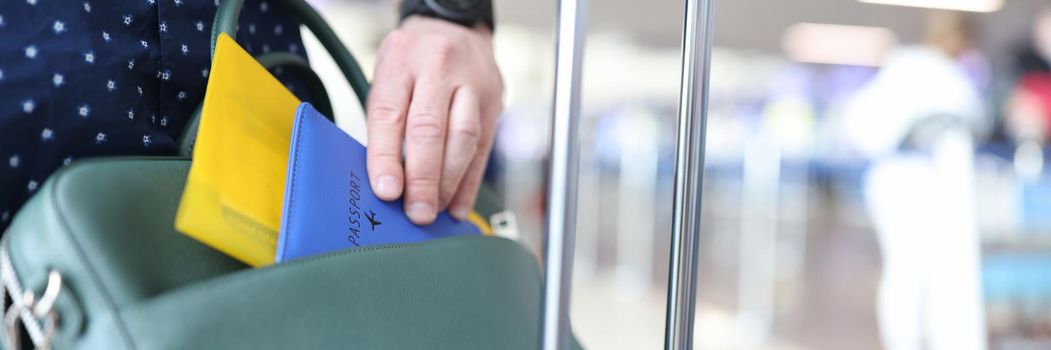 A man puts his passport and tickets in a suitcase