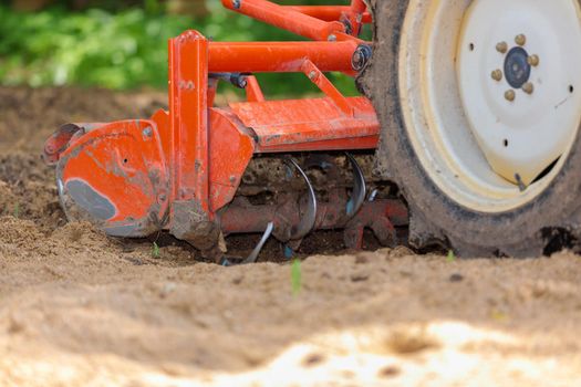 Cultivator for a mini-tractor for loosening the soil. Agricultural work. Excavation. Close-up