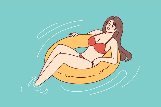 Happy woman in bikini swimming in pool
