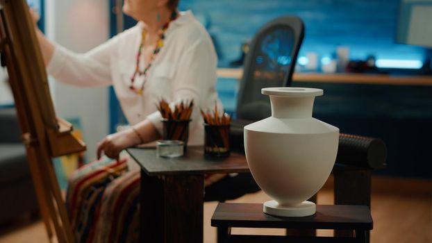 Authentic vase model on table with pencils and artistic tools