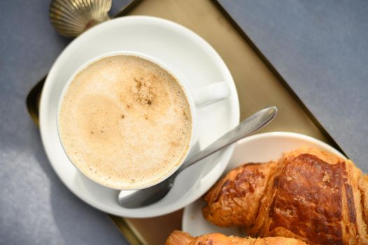 Coffee cup and fresh baked croissant