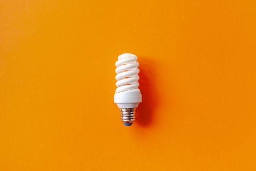 Energy saving light bulb on a orange background