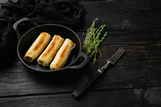 Georgian crepes stuffed on black wooden table background, with copy space for text