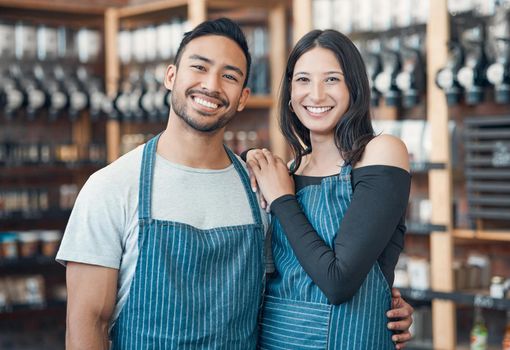 Portrait of a happy young hispanic man and woman working in a store or cafe. Friendly couple and coffeeshop owners managing a successful restaurant startup