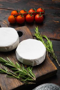 Soft creamy brie cheese on old dark wooden table background