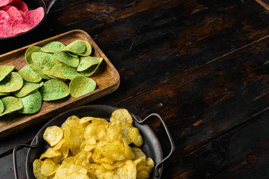 Crispy potato chips on old dark wooden table background, with copy space for text