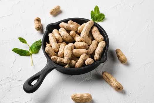 Whole peanut nuts, on white stone table background