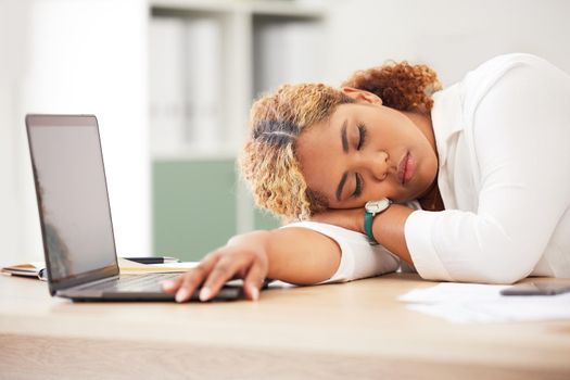 Young Mixed race businesswoman sleeping in a office in front of a laptop on the desk. Latin female lying with her eyes closed