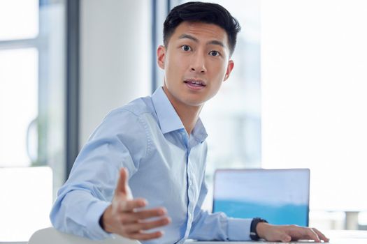 Young asian businessman looking shocked. Businessman turning around with surprised expression. Business professional looking in disbelief. Businessman sitting in front of his laptop looking amazed