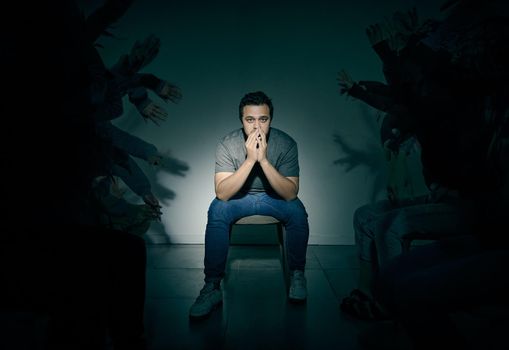 One mixed race male suffering mental illness in asylum. Caucasian schizophrenic man experiencing a breakdown while being surrounded by people on a stage theatre performance