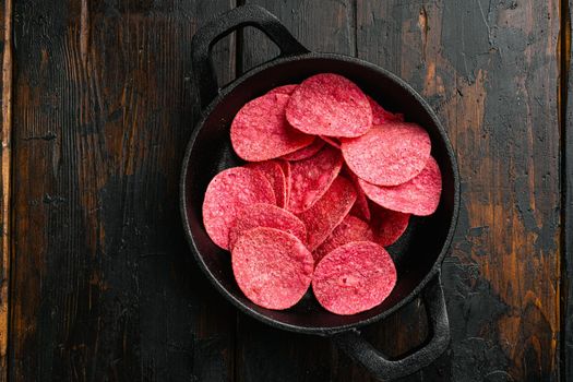 Hickory BBQ Flavored red Potato Chips on old dark wooden table background, top view flat lay, with copy space for text