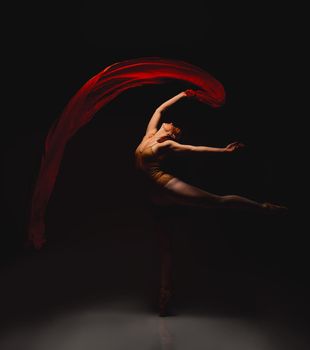 She lives for the arts. Shot of a performer dancing against a dark background.