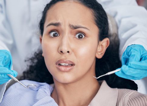 Oh no will this hurt. Shot of a young woman looking afraid at her dentists office.