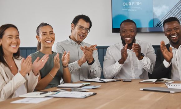 A group of young diverse and confident corporate business people clapping while sitting in the boardroom during a work meeting. Celebrating the success and promotion of a coworker. Were happy for you