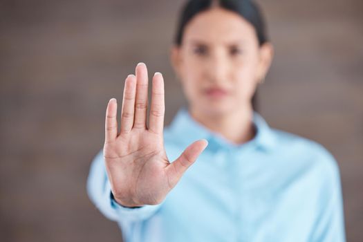 Closeup hand of a mixed race business woman gesturing stop while standing in her office. Stop sexism, inequality and sexual harassment in the workplace. Take a stand. Enough is enough