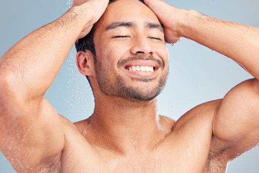 Handsome hispanic man in the shower. Young man enjoying a shower in a studio. Man washing his body in the shower. Young mans bodycare routine. Happy man enjoying a hygienic shower