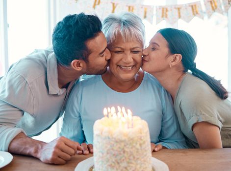 We love you. Shot of two young adults celebrating a birthday with a mature woman at home.