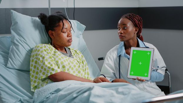 Medical specialist vertically holding green screen on tablet