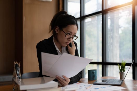 Busy business accountant woman making call phone in office and business working background, tax, accounting, statistics and analytic research concept