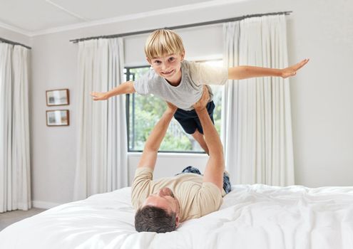 Hes idea of an extreme sport. Shot of a father and son playing in a bedroom at home.