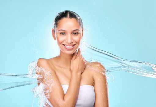 Unveil a youthful glow. Studio shot of clean water splashing against a woman.