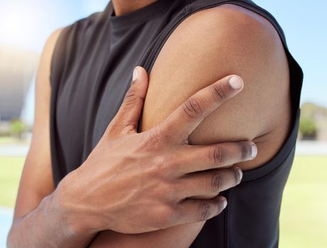 Closeup of african american sportsman suffering from shoulder pain while training. Zoomed in on unknown black man holding and rubbing sore arm with. Overworking muscles causing tension
