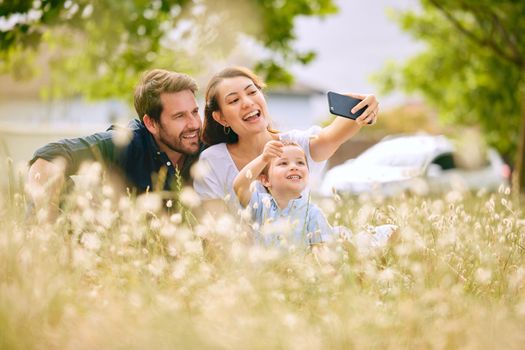 Carefree family days. Shot of a young family taking a selfie while spending time in nature.