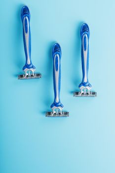 Blue shaving machines in a row on a blue background
