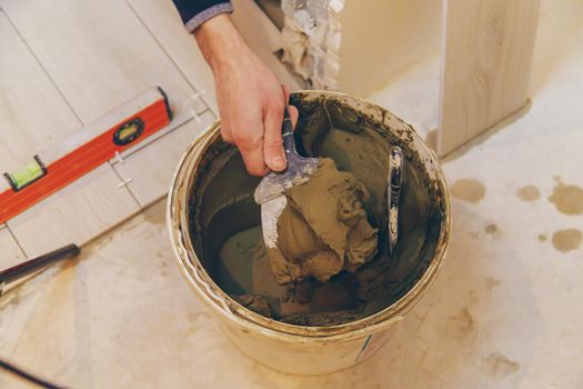 Mix the repair mortar in a bucket. Selective focus.