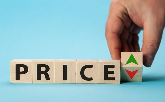 Price growth and decline. Hand changes the position of a block with symbols of growth and decline Price. Price regulator, supply-demand balance, market laws. Economics and free commerce.
