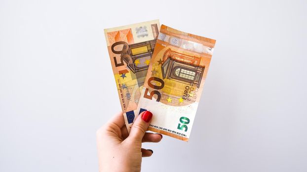Woman's hand with 50 euros money on a white background, copy space for text