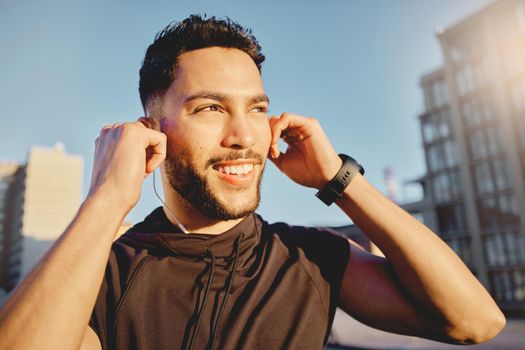 Its a new day. Shot of a sporty young man wearing earphones while exercising outside.